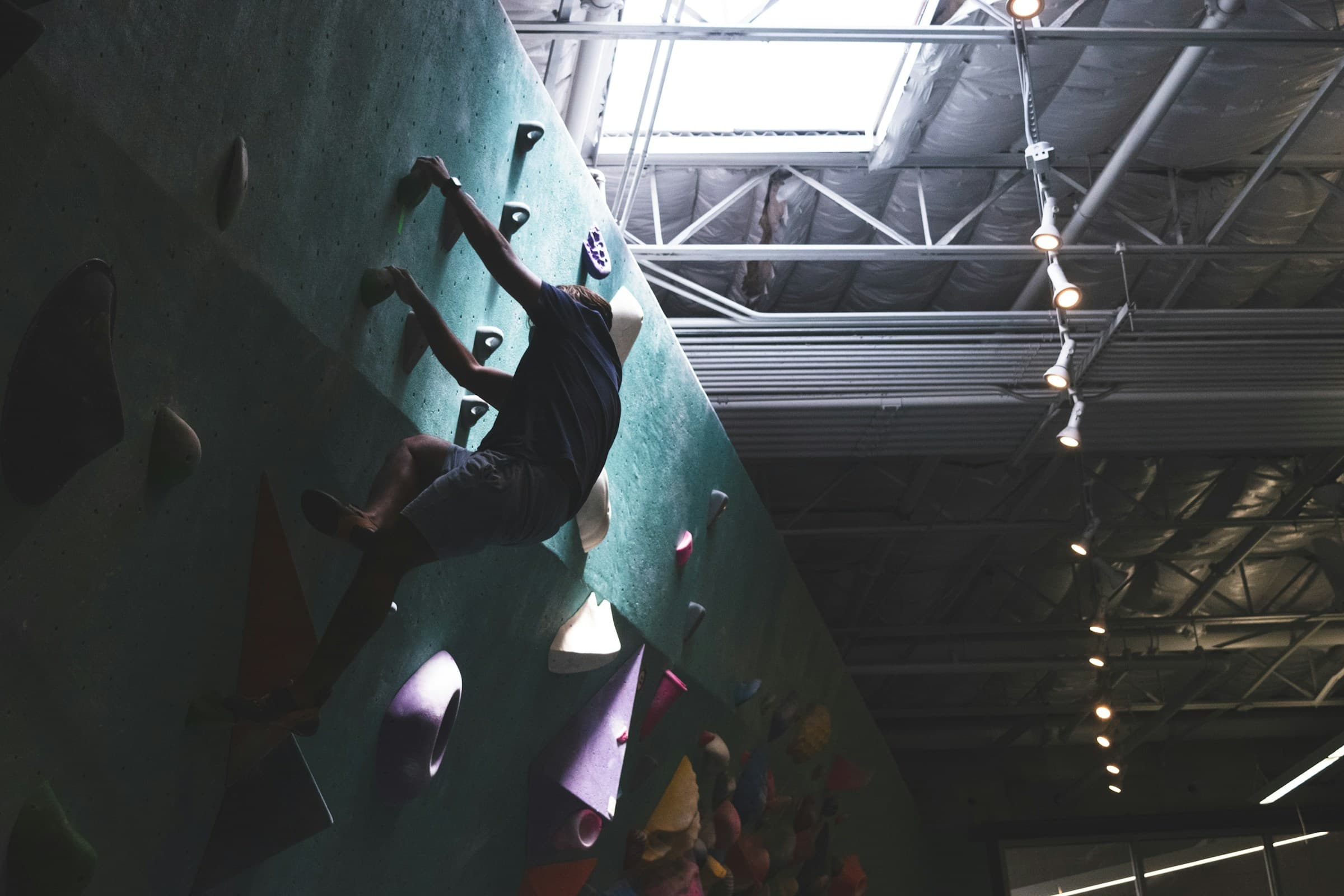 Climber on a dark indoor bouldering wall